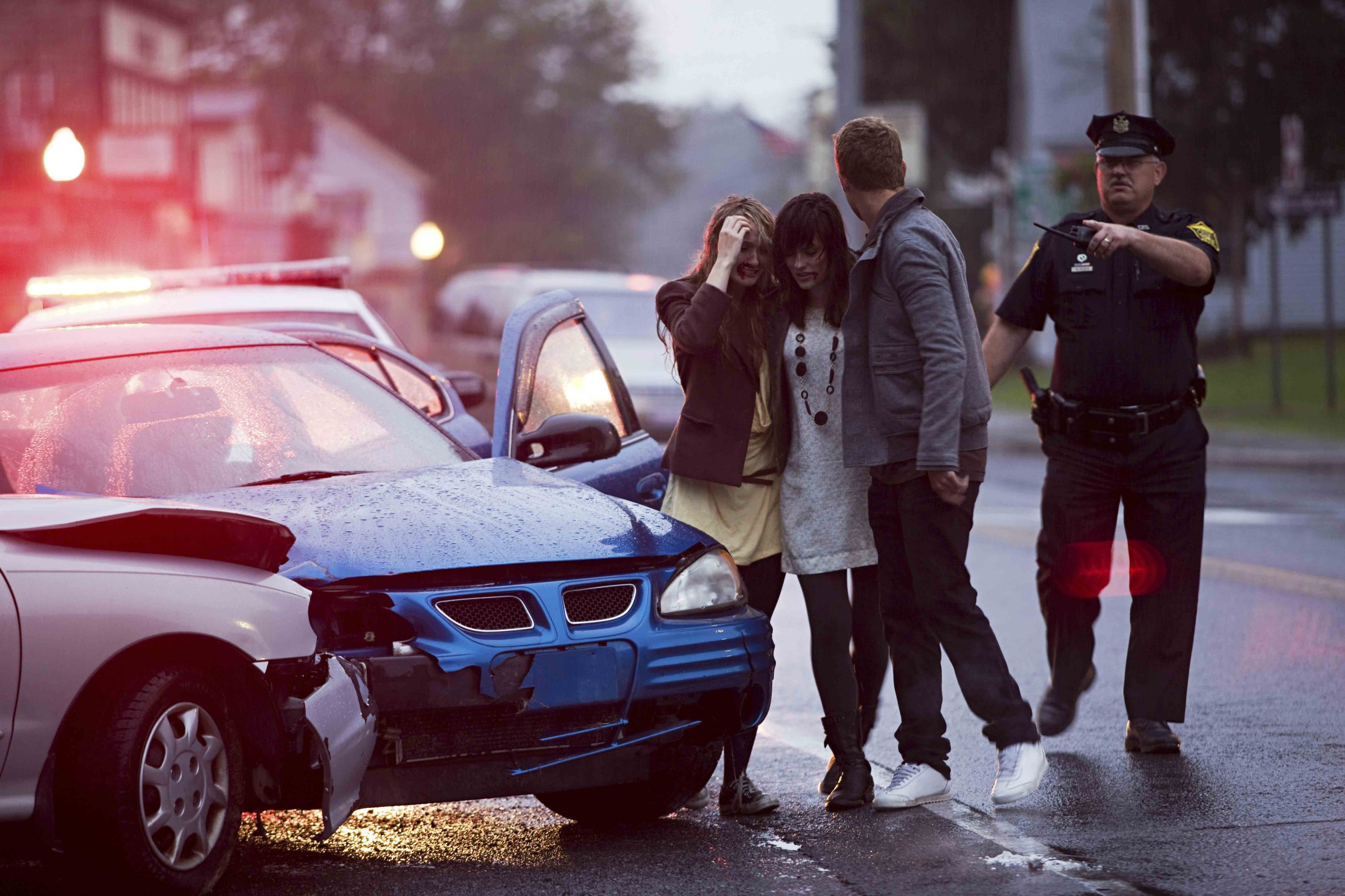 A car collision scene with police officers documenting the accident