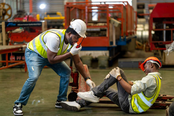 A first responder calling for backup while attending to an injured worker at a construction site