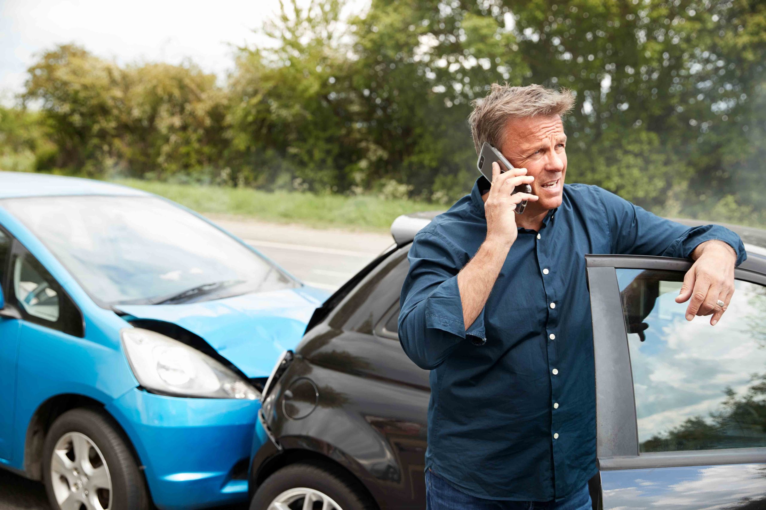 Hand holding a red thumbs down symbol on a white background, signifying avoidance of posting car accidents on social media.