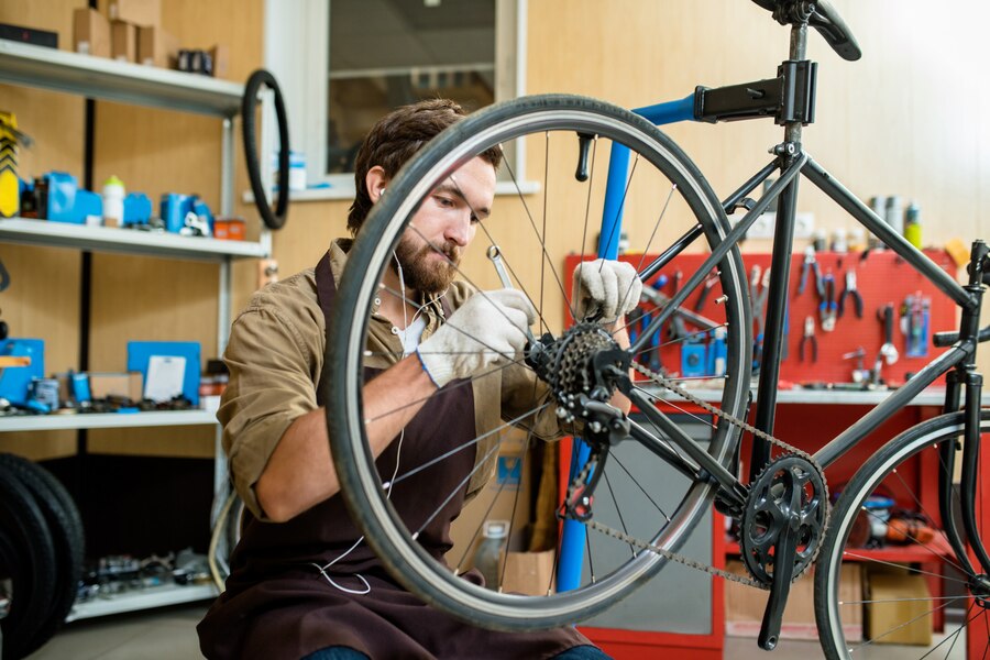 Person repairing a bicycle wheel in a workshop after an accident, documenting repairs for insurance claims.