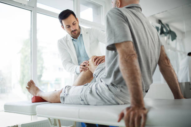 A medical professional examining a patient's leg on an examination table. Illustrates expert witnesses in personal injury cases