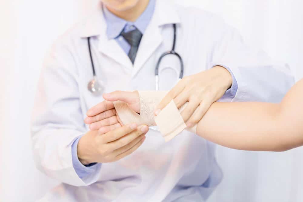 Doctor bandaging a patient's hand after a dog bite, highlighting the medical treatment involved in a dog bite injury claim in Texas