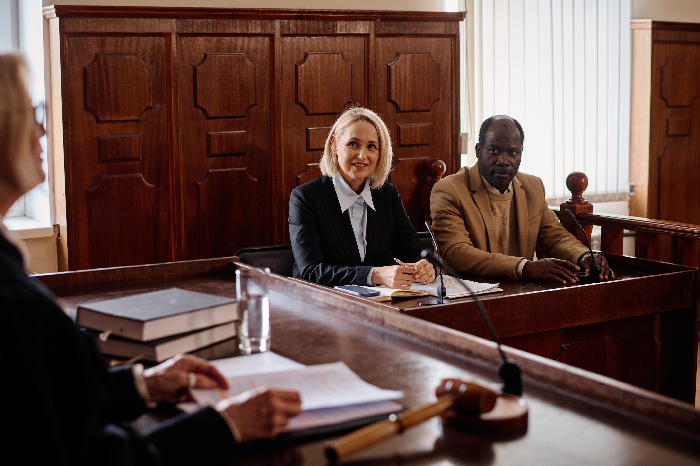 A person in a white lab coat speaking into a microphone at a desk with papers, signifying the importance of expert witnesses in personal injury cases