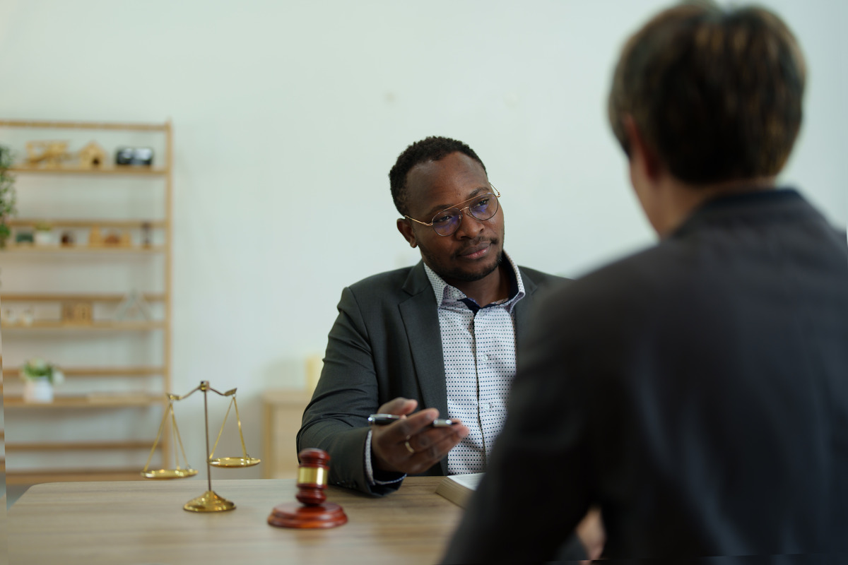 A man in a suit discusses details with an experienced personal injury lawyer regarding a rental car accident injury claim