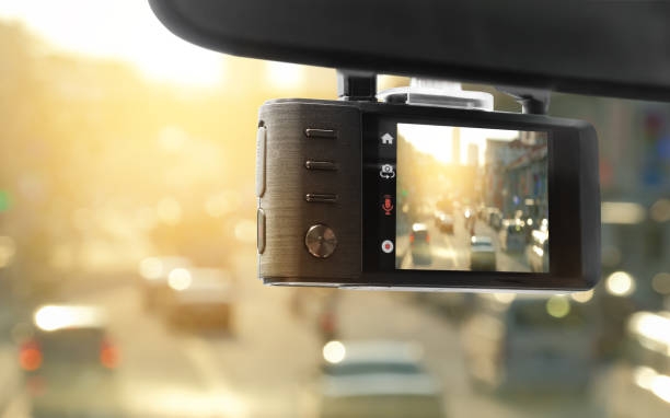 A dashcam attached to the windshield, recording the scenes on the road