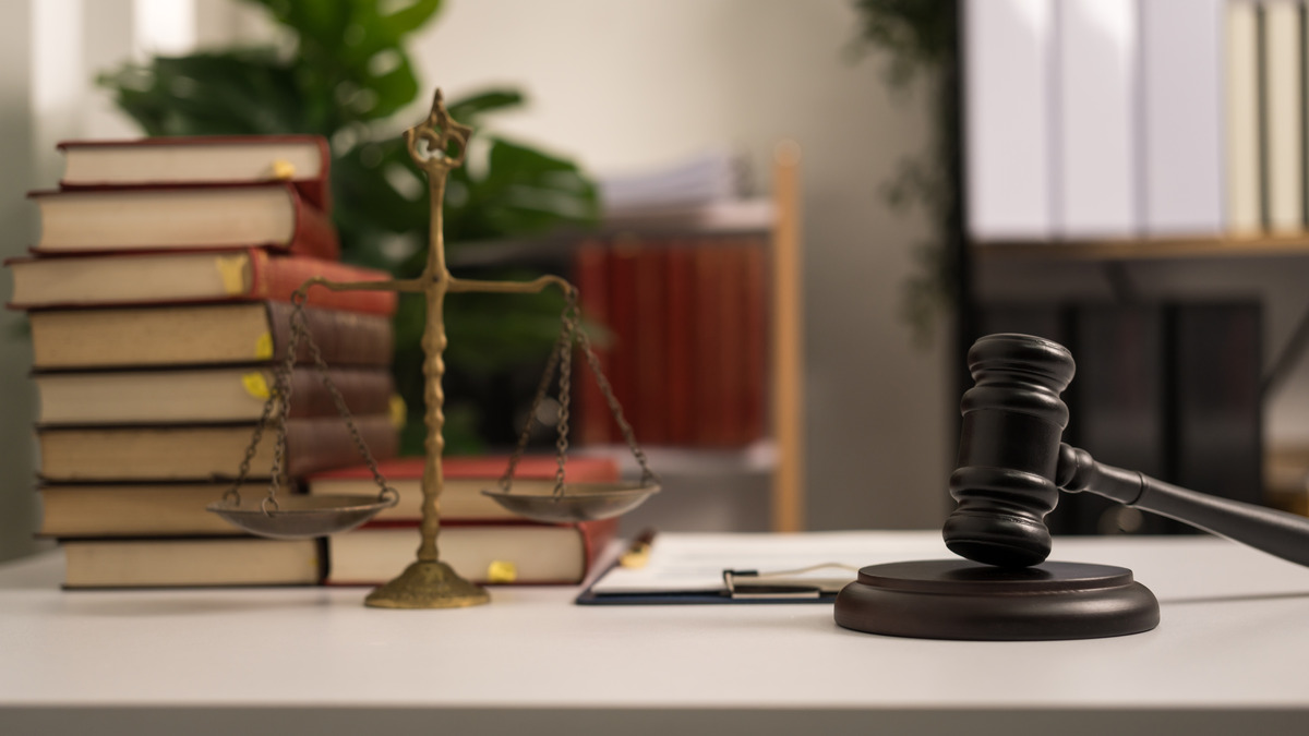 Smiling Attorney Roxell Richards, seated at a desk while shaking hands with client, ready to assist clients in need of justice