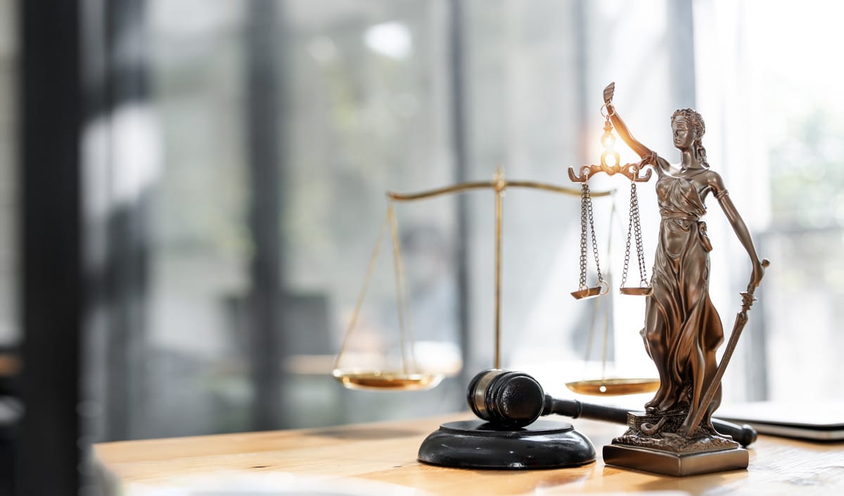 A gavel with a lawsuit document on a table