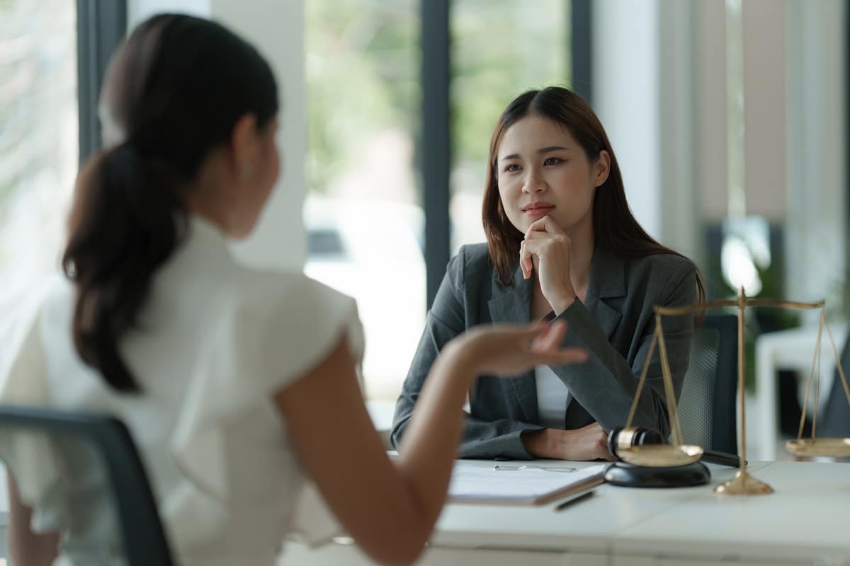 woman meeting with lawyers to review and discuss contract papers, professional legal consultation and agreement review.