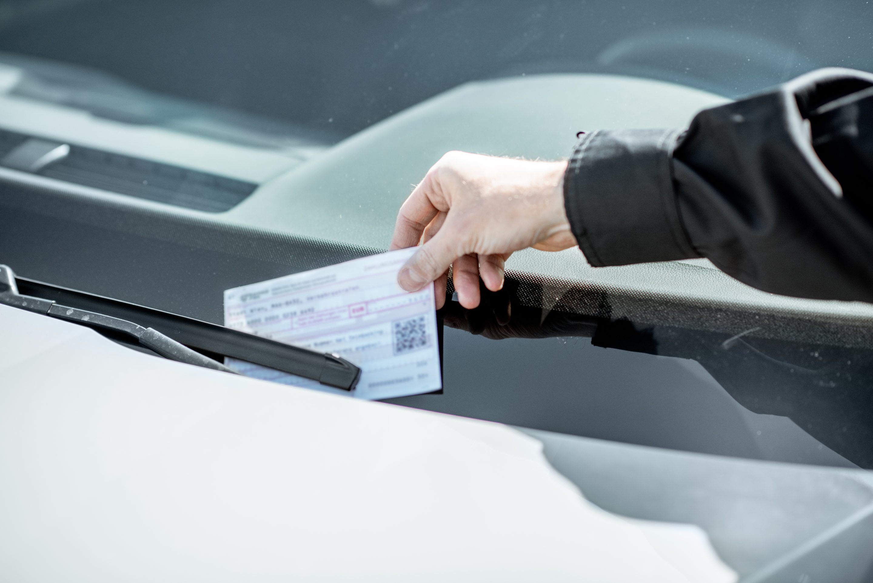 Policeman putting ticket violation on the car's windshield
