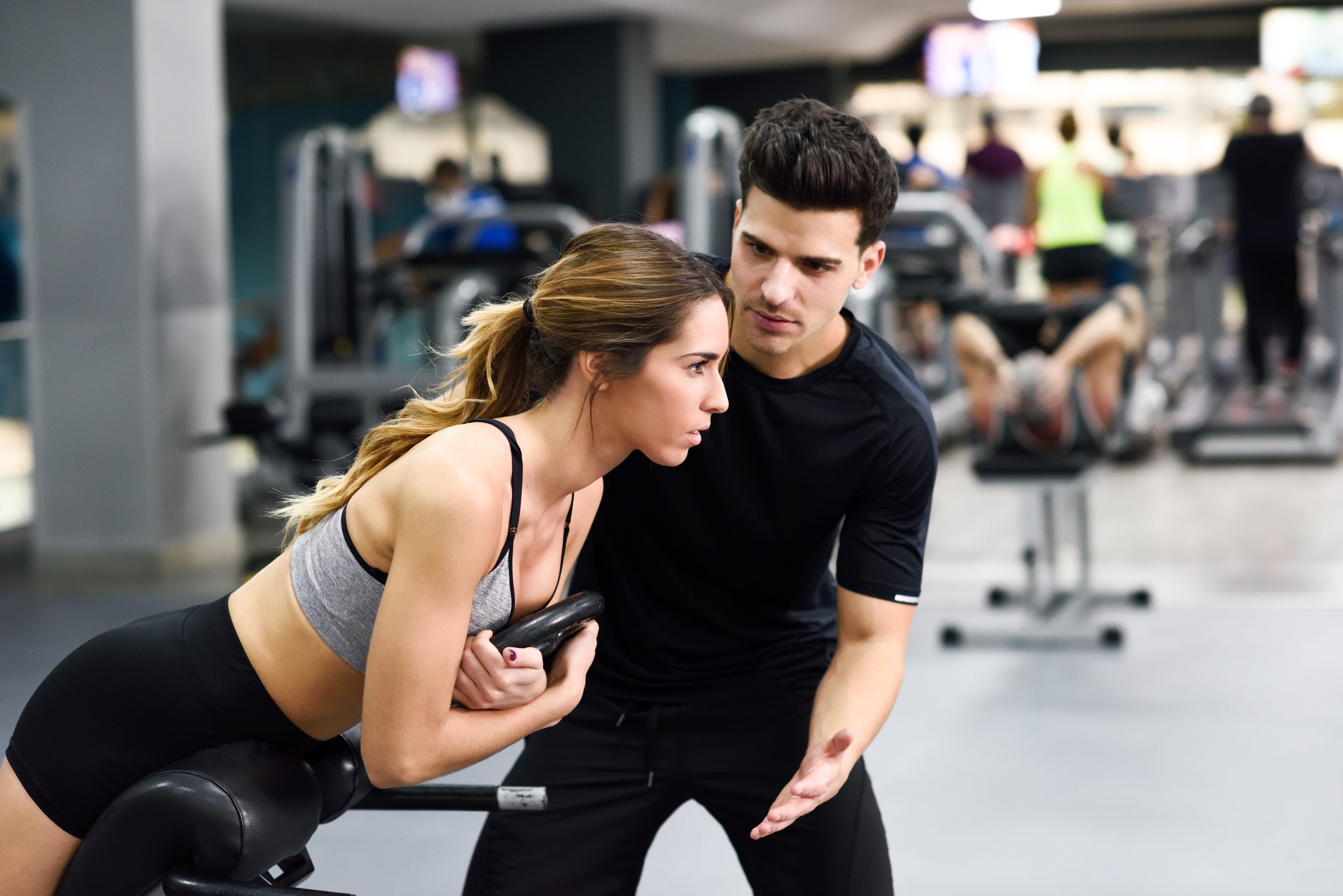 Personal trainer supervising a woman