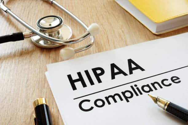 HIPAA Compliance document on a desk next to a stethoscope and a pen for healthcare privacy