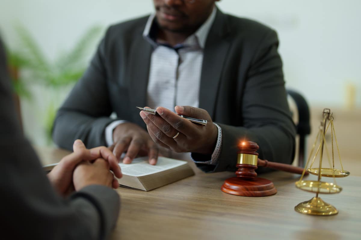 Legal consultation or courtroom scene featuring a judge's gavel, scales of justice, and a law professional discussing a case