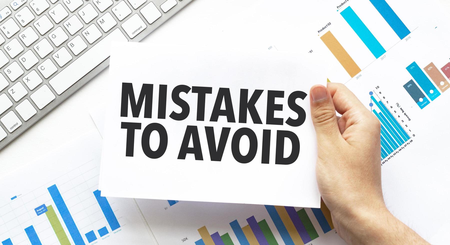 mistakes-to-avoid-words-on-paper-with-charts-and-keyboard-free-photo Business strategy concept featuring a 'Mistakes to Avoid' sign over financial data charts, representing risk management, marketing tips, and professional growth advice