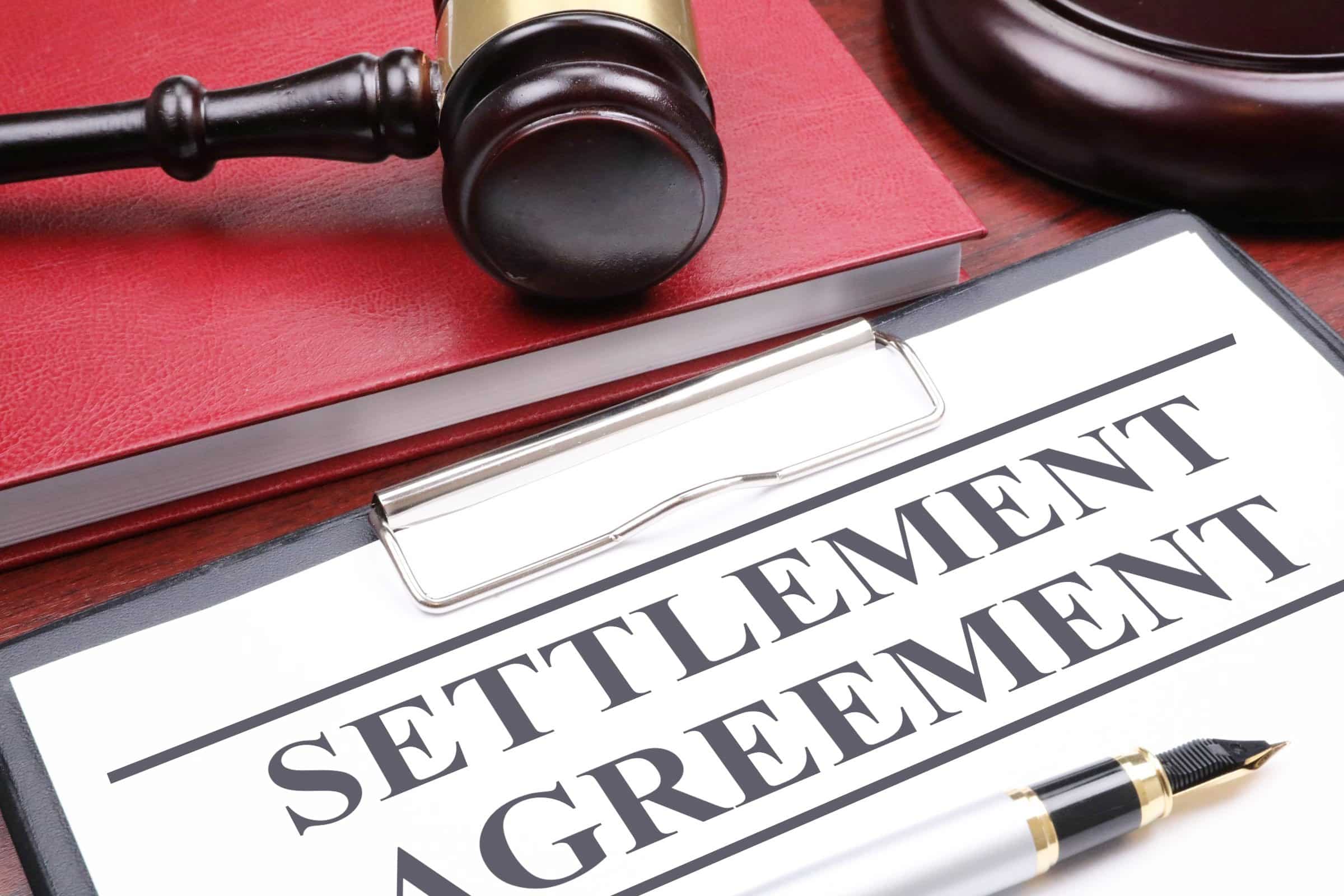 Professional legal documents and a judge gavel symbolizing a finalized settlement agreement in a civil lawsuit